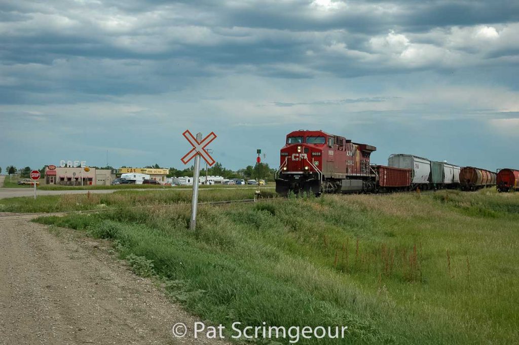 CP 9659 passes the Corner Gas station in "Dog River", SK, July 2005. Contributed by Pat Scrimgeour.