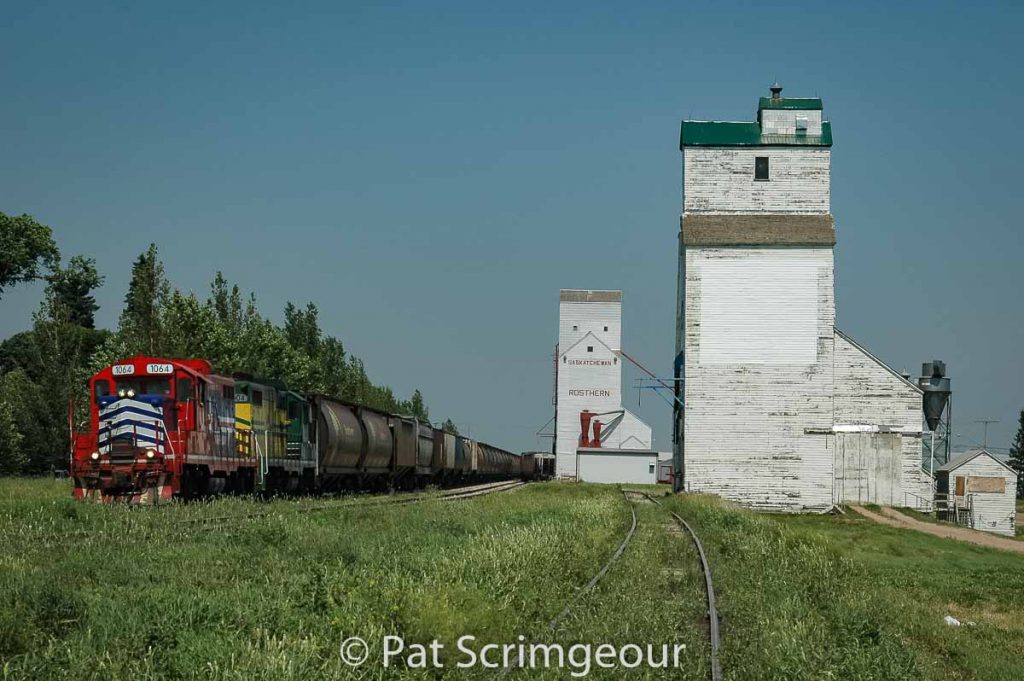 The Carlton Trail Railway rolls past the two grain elevators in Rosthern, SK, June 2006. Contributed by Pat Scrimgeour.