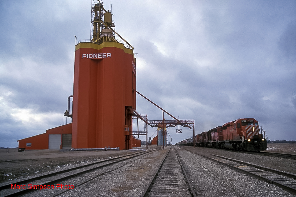 CP 5789 passes the Glossop, MB grain elevator, 1998. Copyright by Marc Simpson.