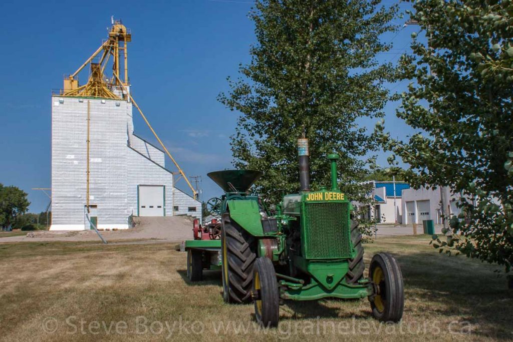 Tractor and grain elevator, Cartwright, MB, Aug 2014. Contributed by Steve Boyko.