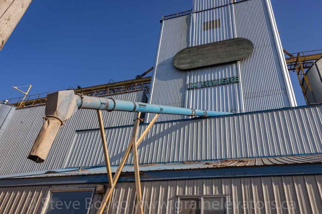 Grain spout and "LA Riviere" sign, Somerset, MB, May 2018. Contributed by Steve Boyko.