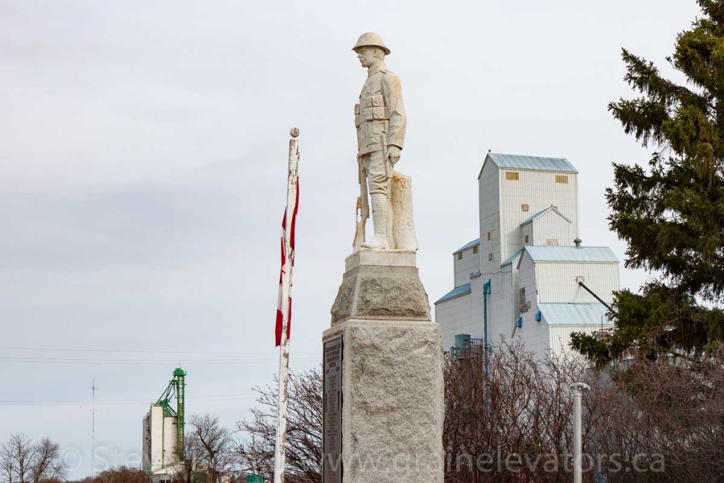 Statue and grain elevators in Newdale, Manitoba, Apr 2017. Contributed by Steve Boyko.