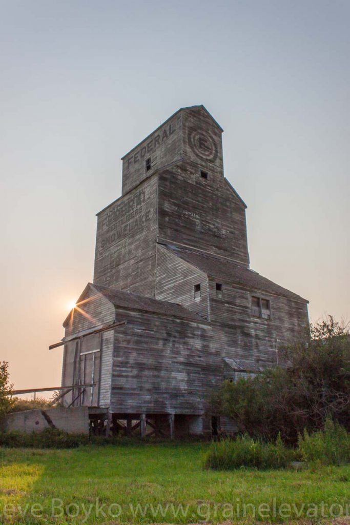 The sun rises behind the former Federal grain elevator in the town of Snowflake, Manitoba.