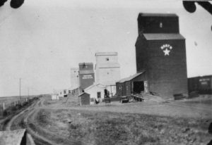 Four grain elevators in Avonlea, SK, 1920.