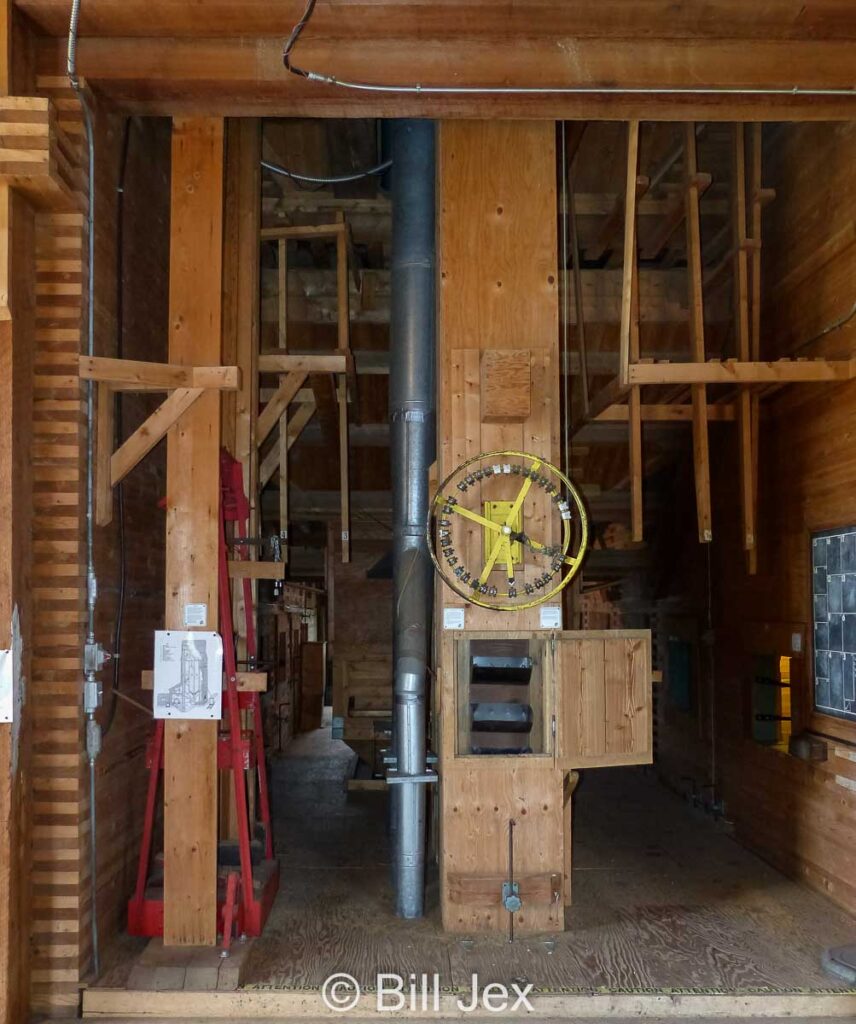 Interior of grain elevator at Big Valley. The manlift is the red item on the left, and the yellow bin selector wheel is centre. Contributed by Bill Jex.