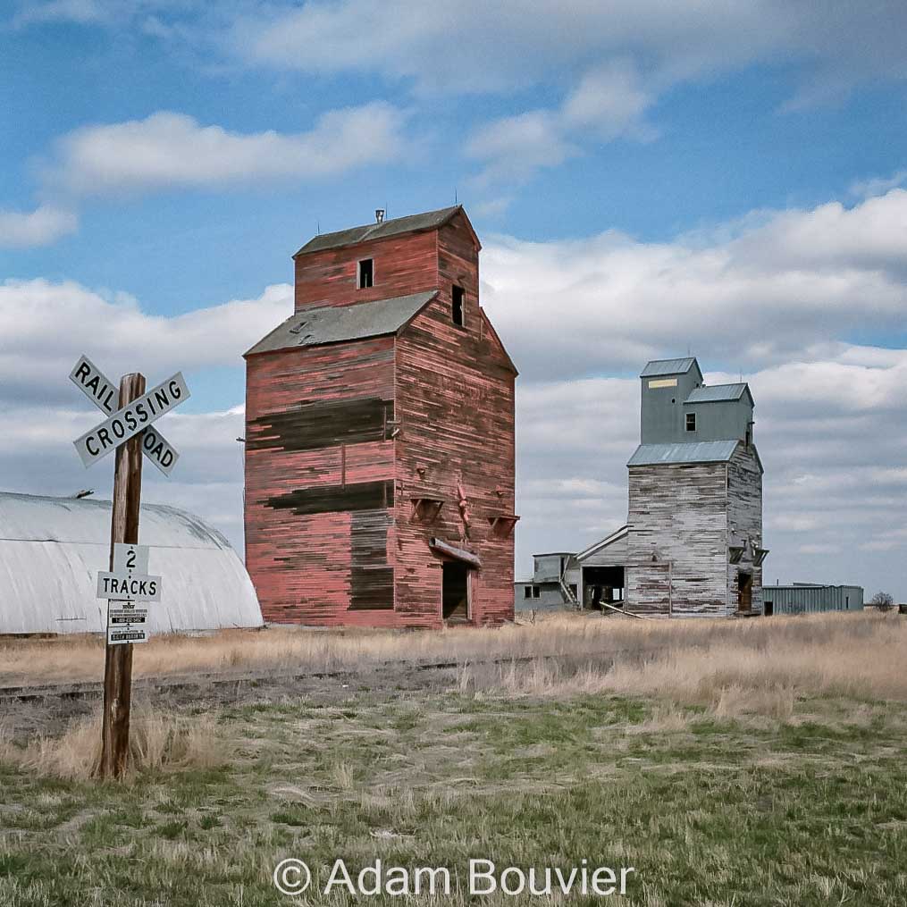 Grain elevators and a railroad crossing sign.