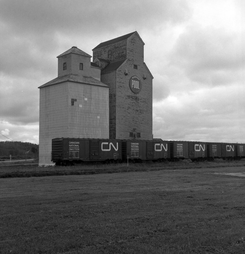 Grain elevator and boxcars in Elphinstone, MB, September 1985.
