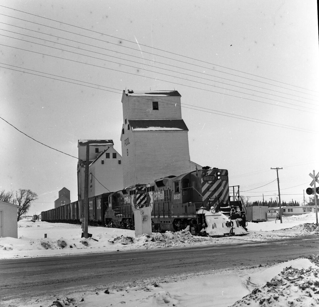 A Canadian Pacific train passes the Miniota, MB grain elevators.