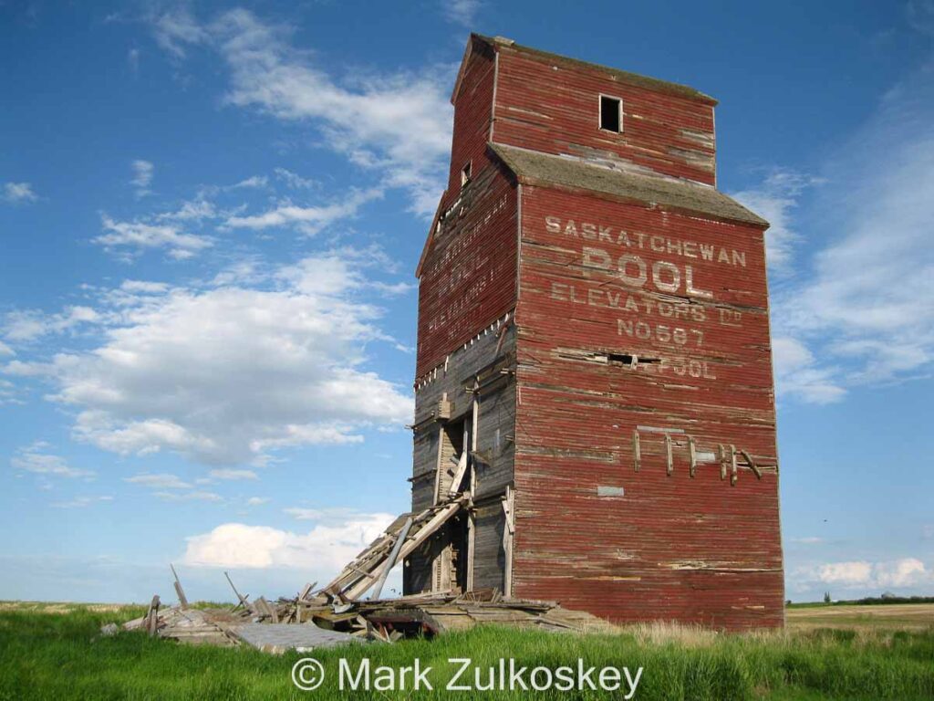 Colour photograph of an old wooden grain elevator with "Saskatchewan Pool Elevators Ltd. No. 597 Whitepool" printed on the side