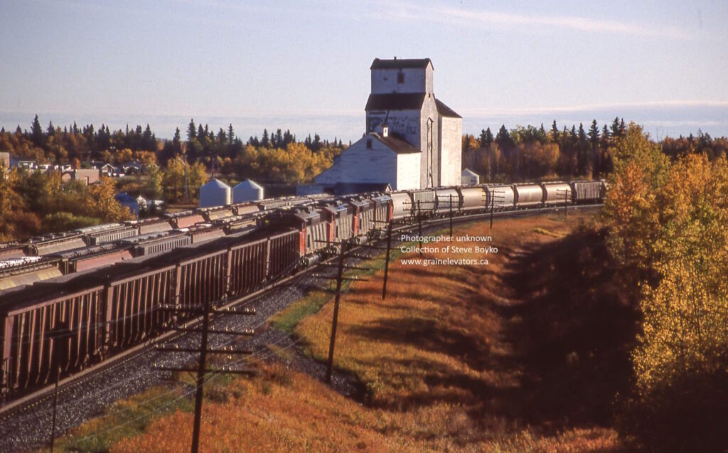 Trains passing by a grain elevator in the autumn