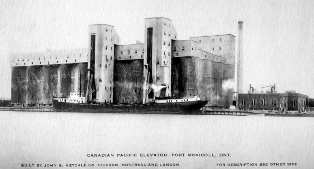 Postcard view of a concrete grain elevator with a ship docked.