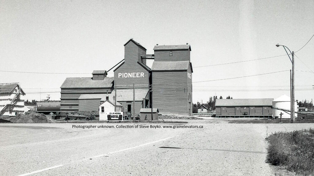 Black and white photograph of a wooden grain elevator with PIONEER printed on the side.