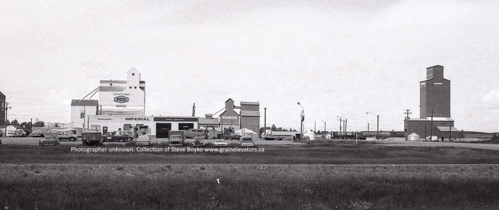 Black and white photograph of wooden grain elevators and an Imperial gas station in Morse Saskatchewan.